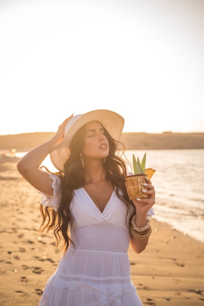 A woman holding a pineapple in white
